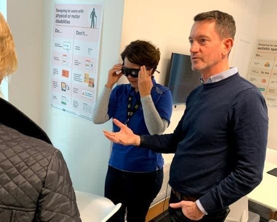 paul and gulcem trying on glasses in the accessibility lab